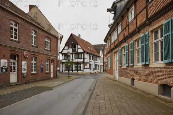Historic brick houses with white windows and shutters and a small half-timbered house in Warendorf, Warendorf district, North Rhine-Westphalia, Germany, Europe