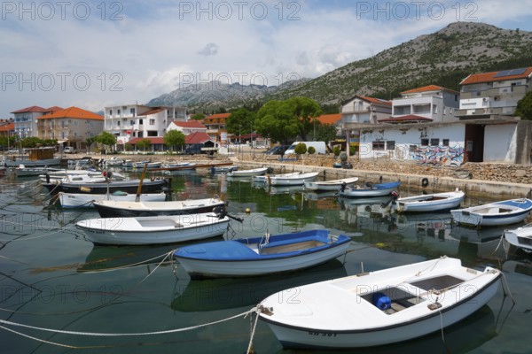 Various boats in a harbour surrounded by mountains and a quiet village panorama, Starigrad, Starigrad-Paklenica, Zadar, Croatia, Europe