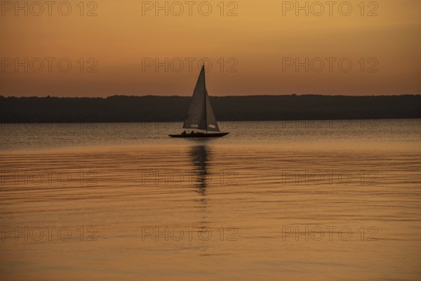 Sailing boat in the sunset with sunset on the Lake Ammer near Herrsching, Bavaria, Germany, Europe