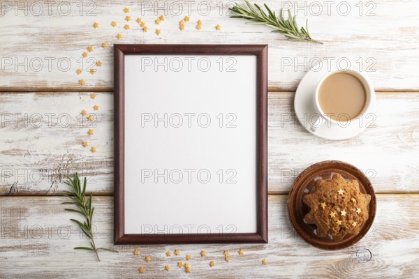 Brown wooden frame mockup with cup of coffee and cake on white wooden background. Blank, top view, flat lay, still life