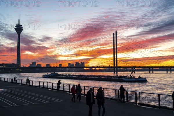Winter sunset on the Rhine near Düsseldorf, riverside promenade at the old town, Rhine Tower, cargo ship, Rheinkniebrücke, North Rhine-Westphalia, Germany, Europe