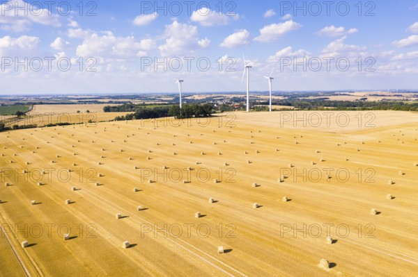Straw bales on a harvested grain field from above, wind turbines in the background, Nossen, Saxony, Germany, Europe