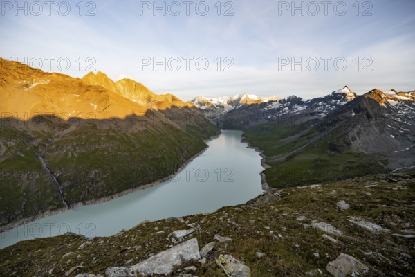 Picturesque mountain landscape at the summit Mont de la Blana at sunset, view of blue mountain lake, reservoir Lac des Dix and summit Mont Blanc de Cheilon with glacier, Hérémence, Valais, Western Alps, Switzerland, Europe