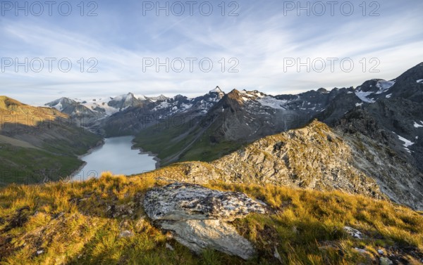 Picturesque mountain landscape at the summit Mont de la Blana at sunset, view of blue mountain lake, reservoir Lac des Dix and summit Mont Blanc de Cheilon with glacier, Hérémence, Valais, Western Alps, Switzerland, Europe