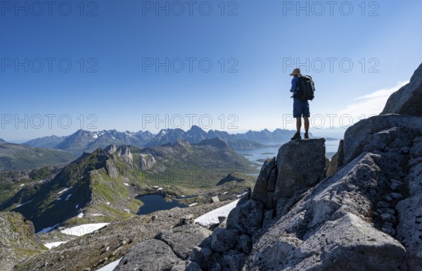 View of mountains and fjord landscape, mountain panorama, mountaineer at the summit of Rundfjellet, lake Hellskarvatnet, Svolvaer, Nordland, Norway, Europe