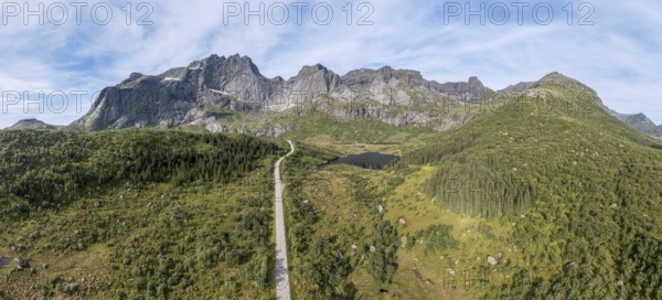 Panoramic aerial view of road in mountain scenery, passing lakes and meadows, road from E10 to village Nusfjord, Lofoten, Norway, Europe