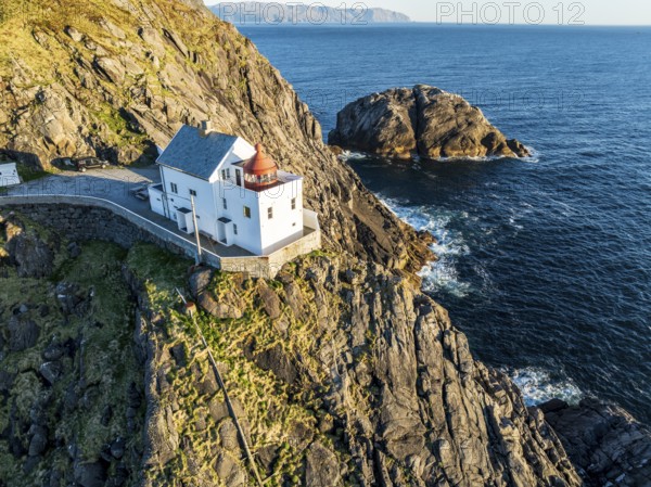 Aerial view of Krakenes Fyr lighthouse, lighthouse located on steep cliff, norwegian coast north of Maloy, Vestland, Norway, Europe