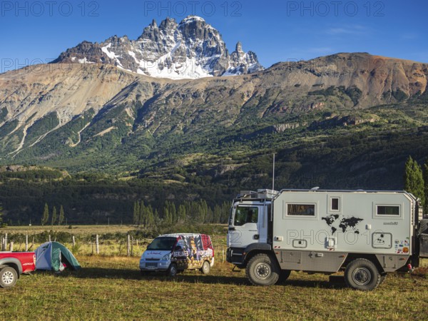 Tents on campsite in village Villa Cerro Castillo, expedition truck, mountain Cerro Castillo in the back, Aysen region, Patagonia, Chile, South America