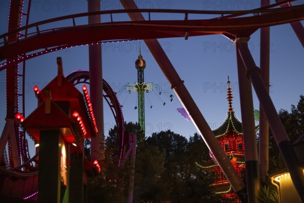 Roller coaster, chain carousel and pagoda at night, Tivoli Amusement and Recreation Park, Copenhagen, Denmark, Europe