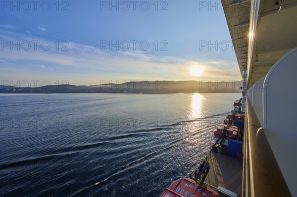 View from a cruise ship, Mein Schiff 6, of the calm sea at sunrise with soft clouds in the sky, Bergen, Vestland, Norway, Europe