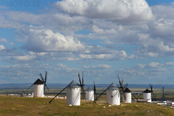 Panoramic view of several white windmills in a vast landscape under a slightly cloudy sky, Campo de Criptana, Ciudad Real province, Castilla-La Mancha, Don Quixote Route, Spain, Europe