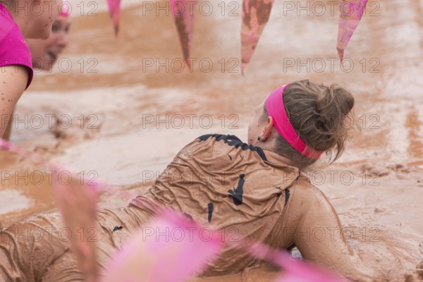 Group of participants in a muddy outdoor obstacle course