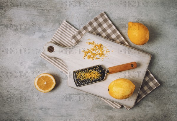 Grated lemon zest, on a cutting board, with a grater, top view, no people