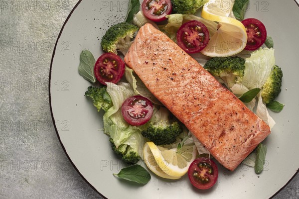 Grilled salmon fillet, with vegetables, broccoli, cherry, iceberg lettuce, spices and herbs, homemade, no people