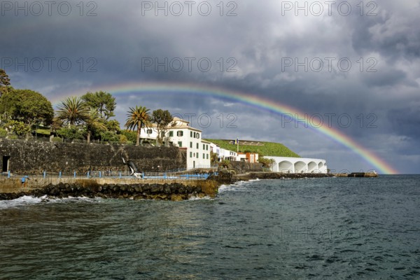 Promenade in rainy weather with rainbow on the beach of the Atlantic Ocean, municipality of Santa Cruz, Madeira, Portugal, Europe