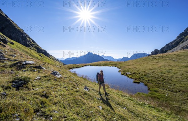 Hiker on the Carnic High Trail, small mountain lake, Carnic Main Ridge, Carnic Alps, Carinthia, Austria, Europe