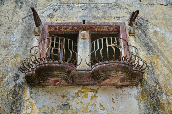 An abandoned balcony with rusty railings and damaged façade on an old building, Italian Governor's Palace, Ruins, Italian colonial settlement, Eleousa, Rhodes, Dodecanese, Greek Islands, Greece, Europe