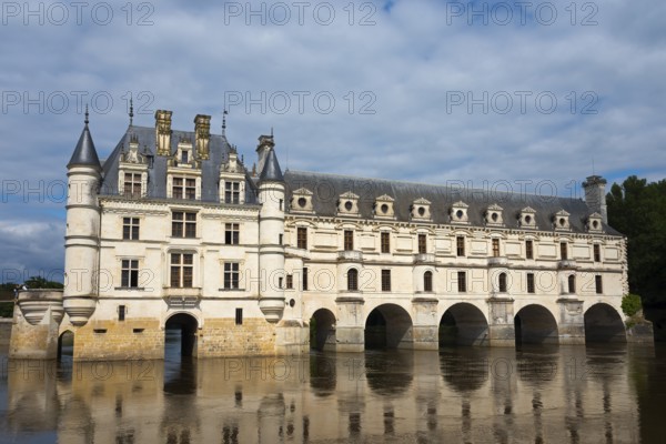 Historic castle with towers and water reflection under a cloudy sky, Chenonceau Castle, Château de Chenonceau, moated castle, Cher River, Chenonceaux, Indre-et-Loire, Centre-Val de Loire, France, Europe
