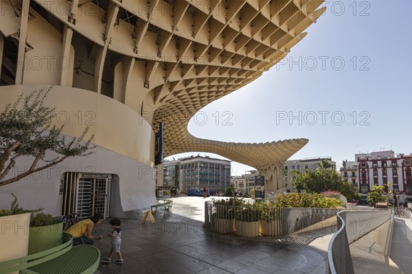 Metropol Parasol with people in the foreground and bright sunshine in the city, Seville