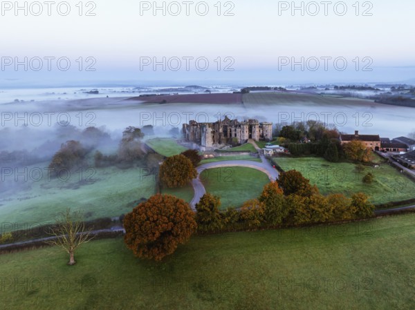Raglan Castle in the fog at dawn from a drone, Monmouthshire, Wales, England, United Kingdom, Europe