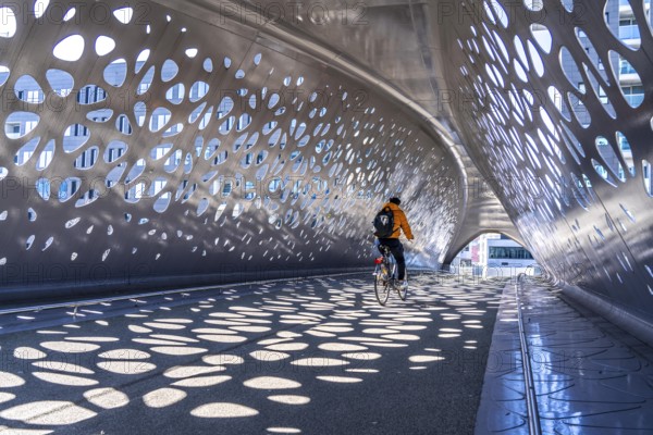 Light effects from the sun in the Parkbruk, a cycle and pedestrian bridge in the city centre of Antwerp, spanning a multi-lane city centre road with tram lines, and thus connecting two lively city districts Kop Spoor Noord and Eilandje, Belgium, without any crossings, Europe