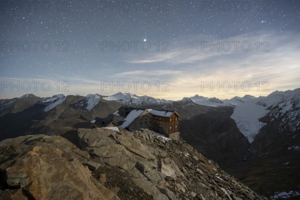Mountain landscape under a starry sky, night shot, mountain hut Ramolhaus in autumn with snow, view of Gurgler Ferner with summit Hochwilde and Falschungsspitze, Ötztal Alps, Tyrol, Austria, Europe