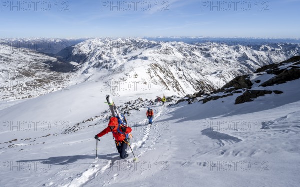 Ski tourer on foot, carrying skis on backpack, mountain panorama, snow-covered mountain landscape in winter, high tour, ascent to Monte Cevedale, Ortler Alps, Vinschgau Valley, Italy, Europe