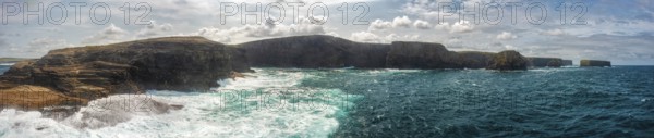 Vast coastal landscape with dramatic cliffs and cloudy skies over the deep blue sea, Kilkee