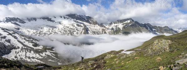 Mountaineer on a hiking trail with high fog in the valley, summit Hochfeiler, Hoher Weißzint and Hochsteller with clouds, glacier Schlegeiskees, Berliner Höhenweg, Zillertal Alps, Tyrol, Austria, Europe