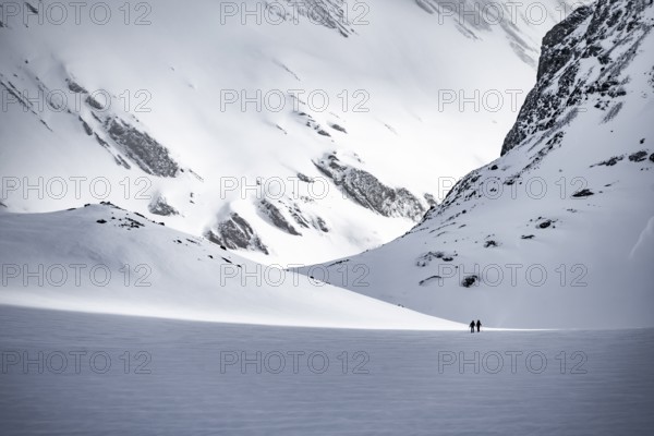 Dramatic atmosphere, Ski tourers in the vast landscape, Snow-covered mountain landscape, Bernese Alps, Bernese Oberland, Switzerland, Europe