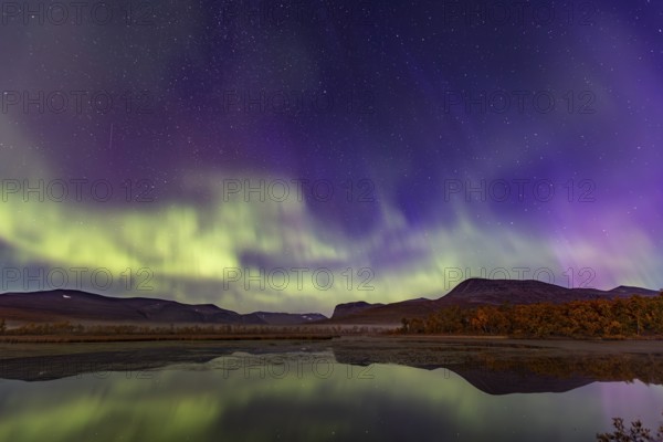 Northern lights, aurora borealis, reflected in lake, mountains, autumn, autumn colours, Nikkaluokta, Laponia, Lapland, Sweden, Europe