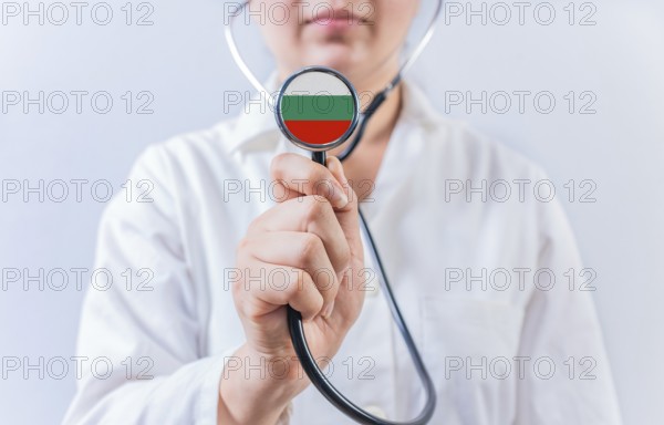Female doctor holding stethoscope with Bulgaria flag. National health system of Bulgaria