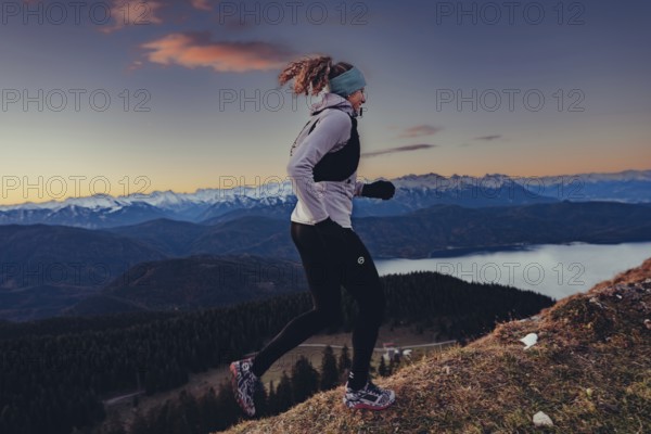 Trail running in autumn on the Jochberg on Lake Walchensee against the wonderful backdrop of the Alps, Bavaria, Germany, Europe