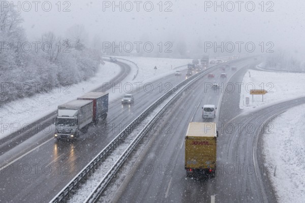 Motorway in snowfall with several trucks and cars on the road, Winnenden, Baden-Württemberg, Germany, Europe