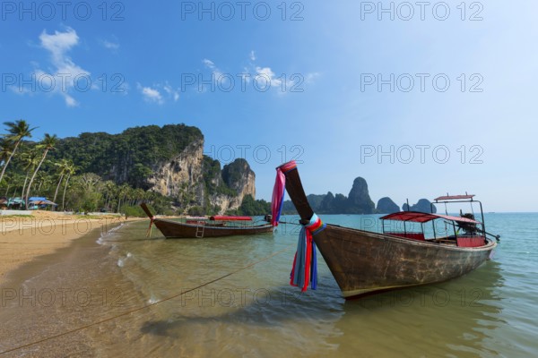 Longtail boat at Torsay beach for transporting tourists, water taxi, taxi boat, ferry, ferry boat, fishing boat, wooden boat, boat, decorated, tradition, cloth, colourful, fabric, decorated, superstition, traditional, bay, sea, ocean, Andaman Sea, tropics, tropical, chalk cliffs, landscape, island, water, travel, tourism, paradisiacal, beach holiday, sun, sunny, holiday, dream trip, holiday paradise, paradise, beach holiday, beach holiday, coastal landscape, nature, idyllic, Siam, exotic, travel photo, Krabi, Thailand, Asia
