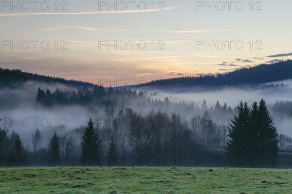 Autumnal evening mood with fog in the valley and in the forests of the Bavarian Forest National Park close to Frauenau