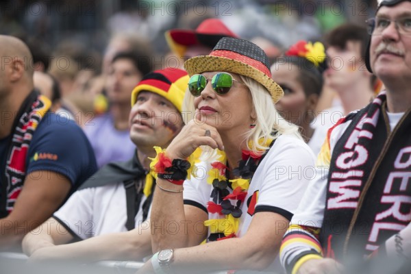 A woman watches the football match in the fan zone at the Brandenburg Tor during the quarter-final match between Germany and Spain at the European Football Championship, Berlin, 05/07/2024