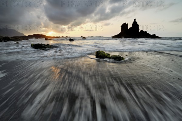Dramatic cloudy atmosphere with rock formation at rising tide at sunset on the beach of Playa de Benijo, Tenerife, Canary Island, Spain, Europe