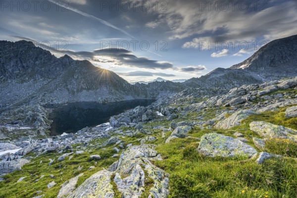 Sunrise over a mountain landscape with wo, ken rocky terrain and mountain lake, Krimml, Salzburg, Austria, Europe