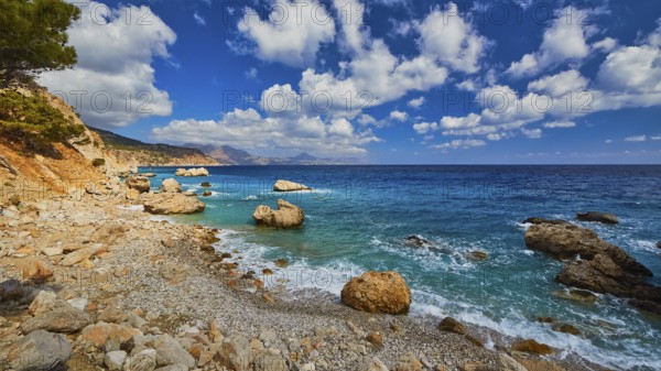 Quiet beach with large rocks framed by deep blue water and a wide sky, Kato Lakkos Beach, still almost unspoilt bay, not accessible by car, Kato Lakkos, East Coast, Karpathos, Dodecanese, Greek Islands, Greece, Europe