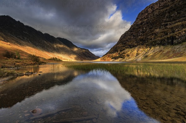 Mountains reflected in lake, evening light, cloudy mood, autumn, Loch Achtriochtan, Glencoe, Scottish Highlands, Scotland, Great Britain