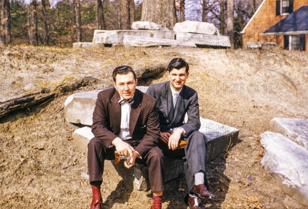Two elegantly dressed men sitting outside and looking into the camera, USA around 1953