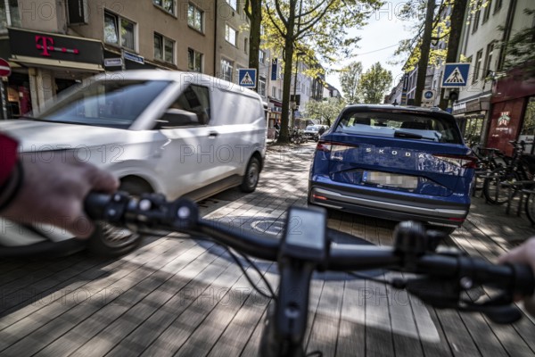 Cycling in the city, inner-city street, cycle lane, bicycles have priority, two-lane traffic with parked cars on both sides, cyclists' perspective, Essen, North Rhine-Westphalia, Germany, Europe