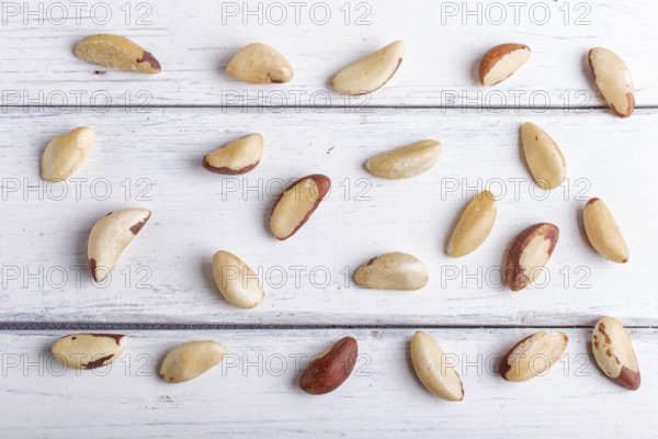 Pattern and texture made from Brazil nuts on white wooden background, flat lay. top view