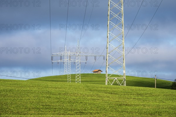 Powerlines of local hydroelectric power station dominate the landscape, rural meadows, Roßhaupten, near lake Forggensee, Bavaria, Germany, Europe