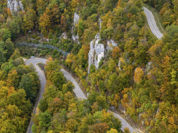 Swabian Alb in autumn, Albtrauf with colourful mixed forest and winding country road. Bad Urach, Baden-Württemberg, Germany, Europe