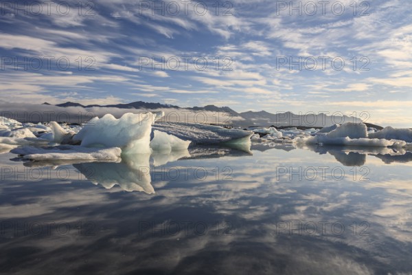 Ice floes, icebergs, reflection, mountains, clouds, sunny, Jökulsarlon, Iceland, Europe