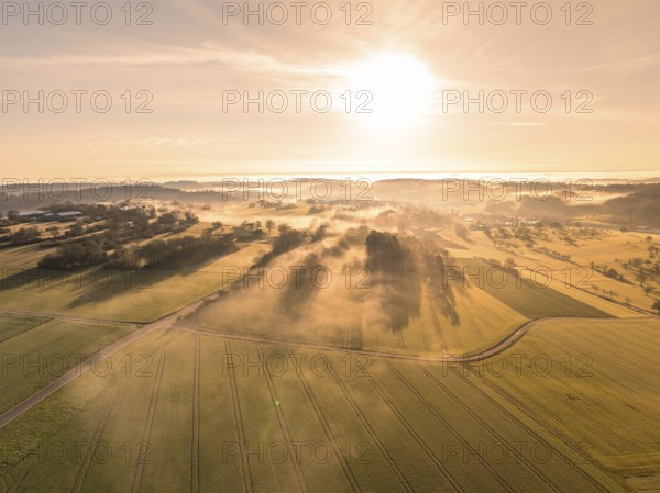 Wide fields in the morning mist and golden light of the sunrise, creating a peaceful atmosphere, Calw, Black Forest, Germany, Europe