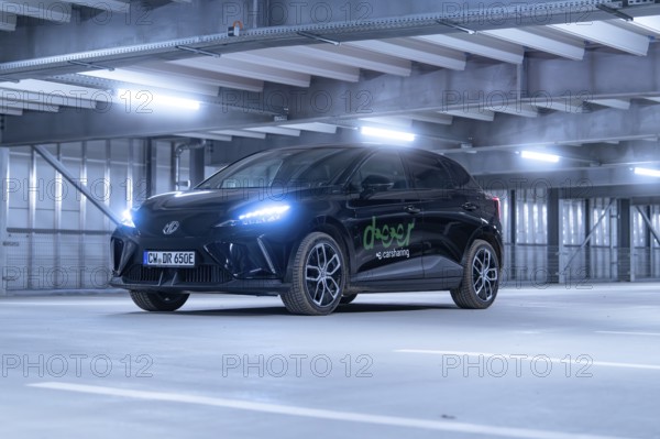 Black car with front lights switched on in car park, e-car sharing, Deer Mobility, MG4, Calw, Germany, Europe