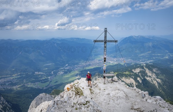 Hiker on the summit of the Alpspitze, Wetterstein range, Bavaria, Germany, Europe